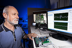 Entomologist Richard Mankin examines signals collected by an inexpensive prototype system (on the bench, at his fingertips) for automated insect detection and identification.
