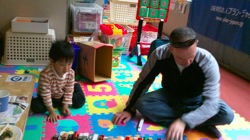Paul playing with a kid in a child friendly space