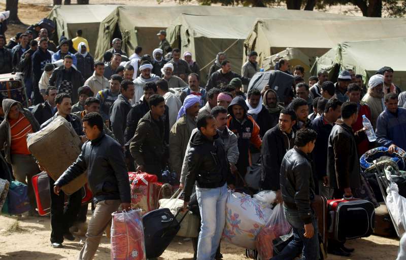 Civilians wait to be processed and interviewed after fleeing to Tunisia to escape the violence in Libya