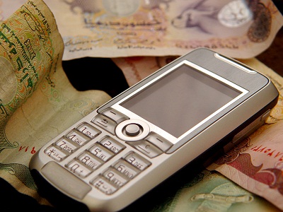 mobile phone resting on paper money